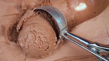 Çikolatalı dondurma topları yavaşça kaşığa konur ve konteynırdan çıkarılır..