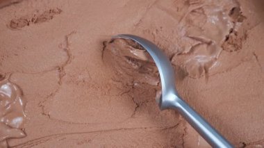 Çikolatalı dondurma topları yavaşça kaşığa konur ve konteynırdan çıkarılır..