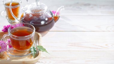 Bir fincan çaydanlıklı çay, arka planda, masada aksesuarlı bir kompozisyon.. 