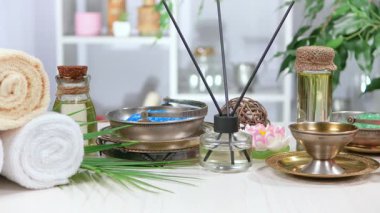 Kaplıca. Masanın üzerindeki hafif arka planda vücut bakımı ve gevşeme malzemeleri. Yavaş bir kamera nesnelerin üzerinde döner.