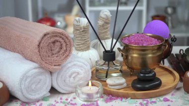 Kaplıca. Masanın üzerindeki hafif arka planda vücut bakımı ve gevşeme malzemeleri. Yavaş bir kamera nesnelerin üzerinde döner.