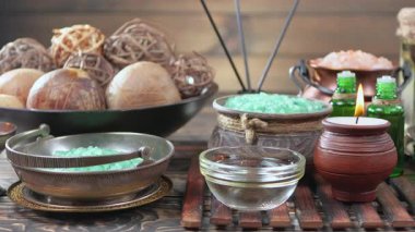 Kaplıca. Masanın üzerindeki hafif arka planda vücut bakımı ve gevşeme malzemeleri. Yavaş bir kamera nesnelerin üzerinde döner.