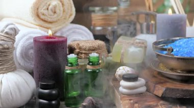 Kaplıca. Masanın üzerindeki hafif arka planda vücut bakımı ve gevşeme malzemeleri. Yavaş bir kamera nesnelerin üzerinde döner.