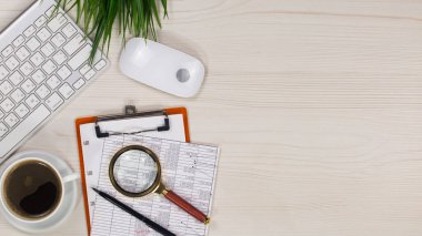 İş ve muhasebe malzemeleri bir ofis masasında düzenlenmiştir. Üst görünüm.