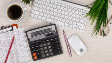 İş ve muhasebe malzemeleri bir ofis masasında düzenlenmiştir. Üst görünüm.