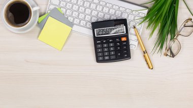 İş ve muhasebe malzemeleri bir ofis masasında düzenlenmiştir. Üst görünüm.