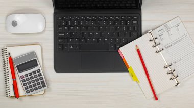 İş ve muhasebe malzemeleri bir ofis masasında düzenlenmiştir. Üst görünüm.