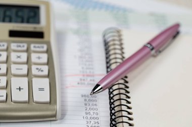 Ofisteki iş ve muhasebe öğeleri masanın üzerinde, kompozisyonda sergilenmiş..