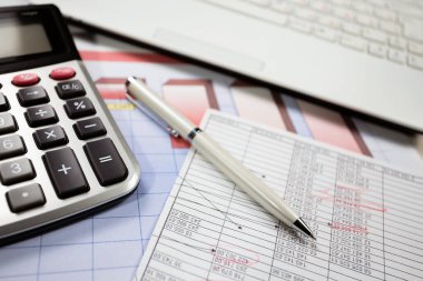 Ofisteki iş ve muhasebe öğeleri masanın üzerinde, kompozisyonda sergilenmiş..