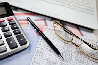 Ofisteki iş ve muhasebe öğeleri masanın üzerinde, kompozisyonda sergilenmiş..