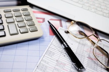 Ofisteki iş ve muhasebe öğeleri masanın üzerinde, kompozisyonda sergilenmiş..