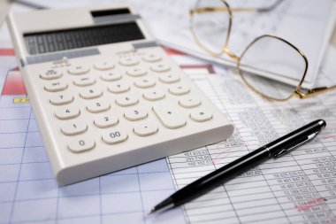 Ofisteki iş ve muhasebe öğeleri masanın üzerinde, kompozisyonda sergilenmiş..