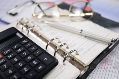 Ofisteki iş ve muhasebe öğeleri masanın üzerinde, kompozisyonda sergilenmiş..