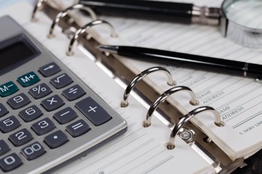 Ofisteki iş ve muhasebe öğeleri masanın üzerinde, kompozisyonda sergilenmiş..