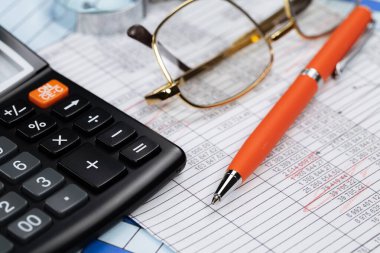 Ofisteki iş ve muhasebe öğeleri masanın üzerinde, kompozisyonda sergilenmiş..