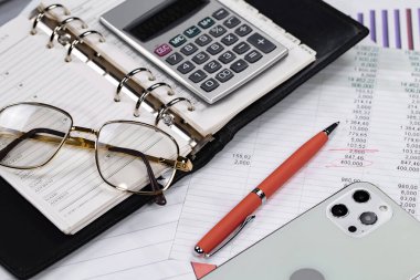 Ofisteki iş ve muhasebe öğeleri masanın üzerinde, kompozisyonda sergilenmiş..