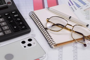 Ofisteki iş ve muhasebe öğeleri masanın üzerinde, kompozisyonda sergilenmiş..