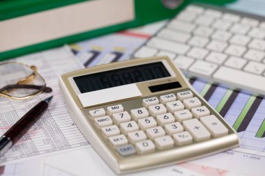 Ofisteki iş ve muhasebe öğeleri masanın üzerinde, kompozisyonda sergilenmiş..