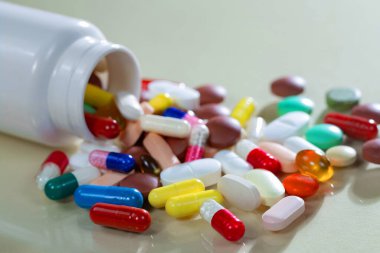 Kapsüllerdeki renkli tabletler kutudan masaya döküldü..