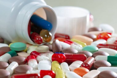 Kapsüllerdeki renkli tabletler kutudan masaya döküldü..