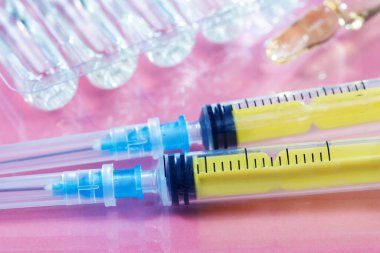 Pembe arka planda iğneler için tıbbi şırıngalar.