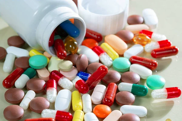 Kapsüllerdeki renkli tabletler kutudan masaya döküldü..