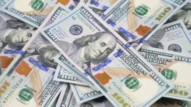 Rastgele düzenlenmiş, yavaşça dönen 100 dolarlık banknotlar. Yukarıdan görüntüle.