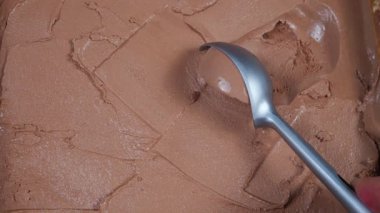 Metal bir kapta çikolatalı dondurma. Paket kaşığıyla çıkarılmış..