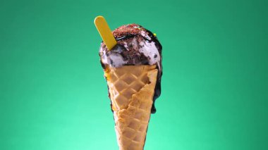 Waffle külahındaki dondurma, parlak bir arkaplanda kendi ekseni etrafında yavaşça döner.