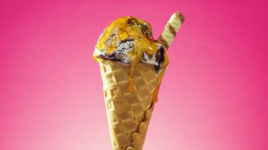 Waffle külahındaki dondurma, parlak bir arkaplanda kendi ekseni etrafında yavaşça döner.
