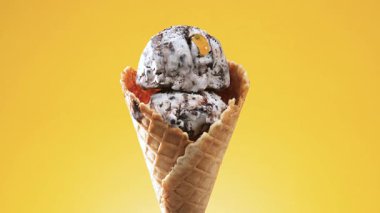 Waffle külahındaki dondurma, parlak bir arkaplanda kendi ekseni etrafında yavaşça döner.