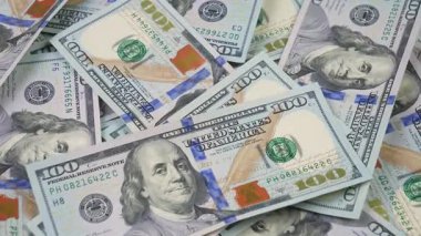 Rastgele düzenlenmiş, yavaşça dönen 100 dolarlık banknotlar. Yukarıdan görüntüle.