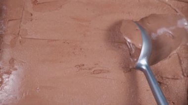 Metal bir kapta çikolatalı dondurma. Paket kaşığıyla çıkarılmış..
