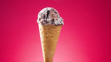 Waffle külahındaki dondurma, parlak bir arkaplanda kendi ekseni etrafında yavaşça döner.