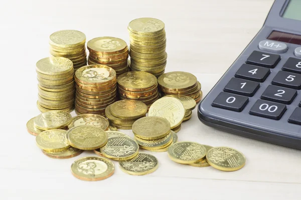 Arany érmék és számológép - üzleti koncepció — Stock Fotó