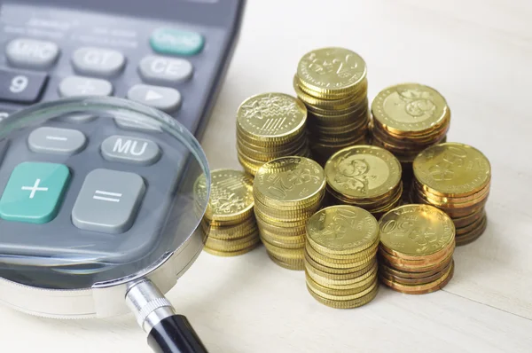 Золоті монети, Калькулятор і Магнітне скло - бізнес-концепція — стокове фото