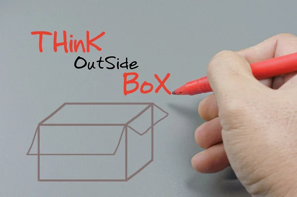 Χέρι γράφοντας σκέφτεται έξω από το κουτί - επιχειρηματική ιδέα — Φωτογραφία Αρχείου