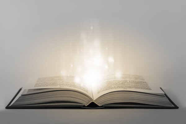 Single glowing unreal old magical book with energy inside. Conceptual image