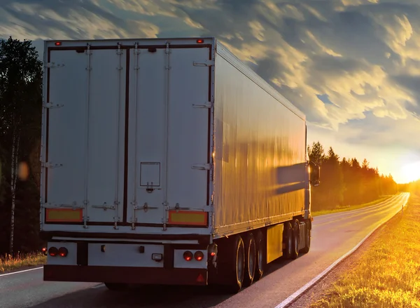 White truck on the rural road at sunset — Stockfoto