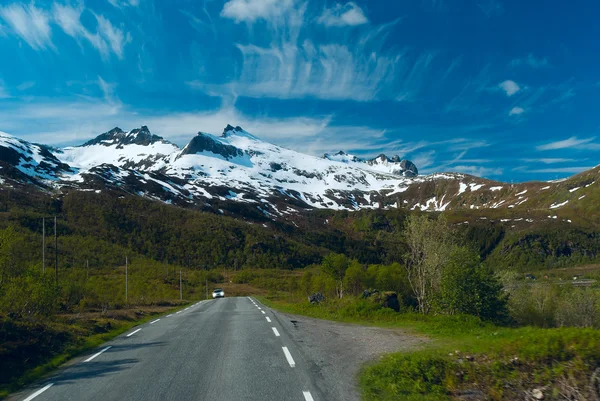 Carro na estrada de asfalto para as montanhas Norvegianas em sol claro da — Fotografia de Stock