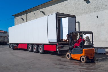 Yükleyici kaldırma beyaz yarı römork üzerinde çalışan 