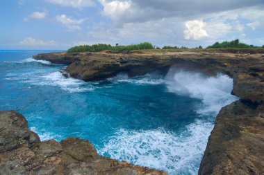 Bal yakınındaki Lembongan Island yakınındaki kayaların üzerinde sörf