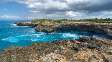 Lembongan Adası Bali yakınındaki yakınındaki kayaların üzerinde sörf
