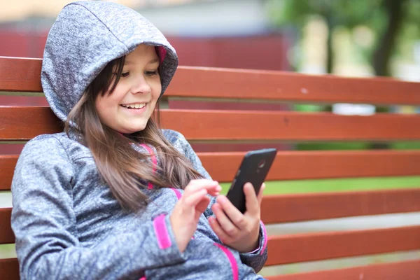 Fille lit sur le téléphone — Photo