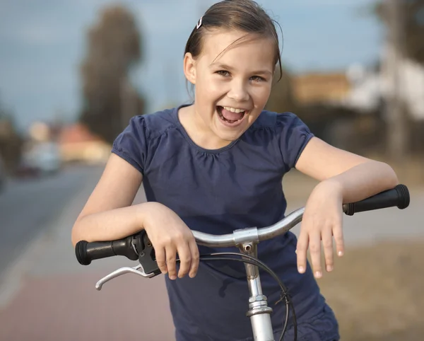 Sevimli kız bisiklet üzerinde oturuyor — Stok fotoğraf