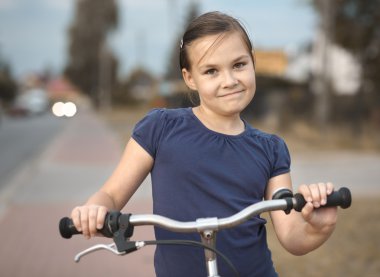 Sevimli kız bisiklet üzerinde oturuyor