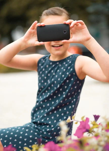 Menina está fotografando usando smartphone — Fotografia de Stock