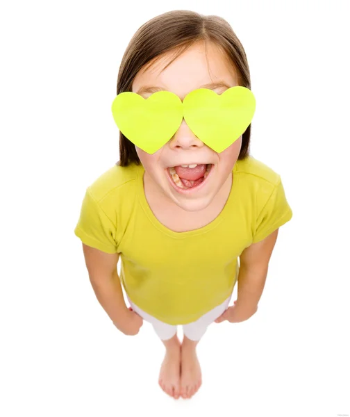 Little girl is holding hearts over her eyes — Stock Photo, Image