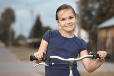 Sevimli kız bisiklet üzerinde oturuyor