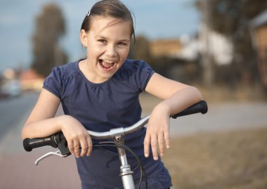 Sevimli kız bisiklet üzerinde oturuyor